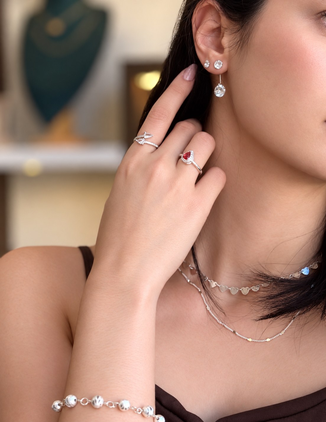 Modelo usando brincos, anéis, pulseira e colares Cravo Dourado